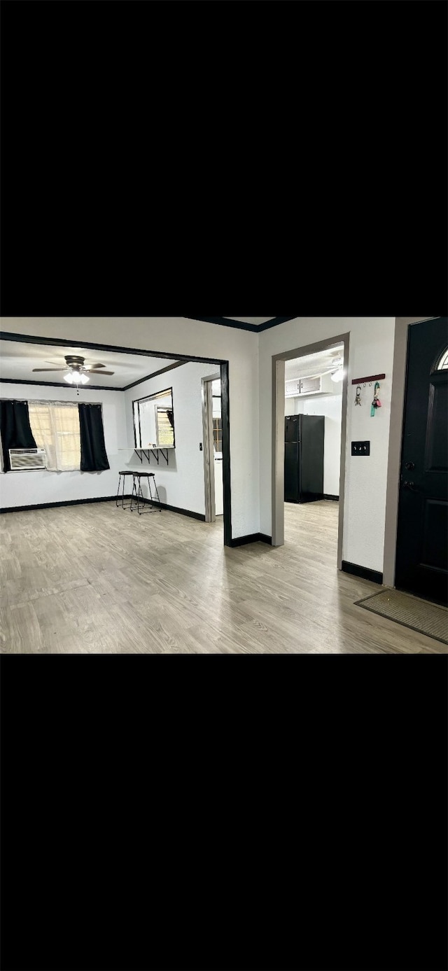 interior space with black fridge, ceiling fan, and light wood-type flooring