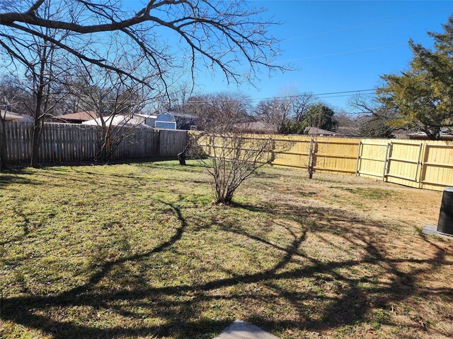 view of yard with a fenced backyard and central AC