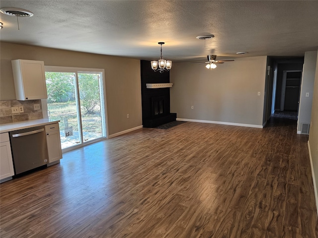 unfurnished living room featuring dark hardwood / wood-style flooring, a textured ceiling, and ceiling fan with notable chandelier