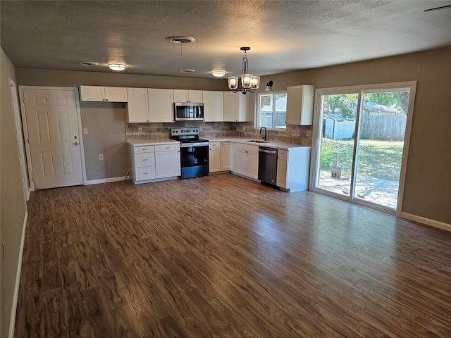 kitchen with appliances with stainless steel finishes, dark wood-type flooring, a sink, and white cabinetry