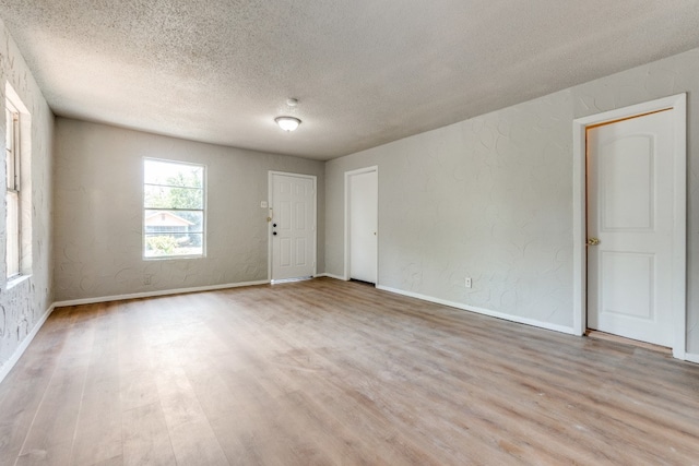 empty room featuring wood-type flooring and a textured ceiling