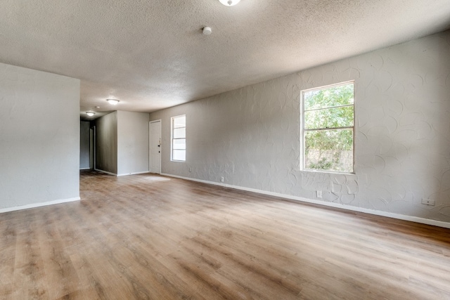 empty room with a textured ceiling and hardwood / wood-style floors