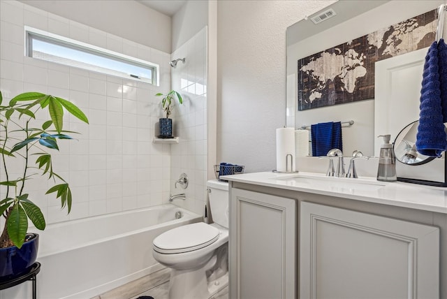 full bathroom featuring toilet, tiled shower / bath combo, and vanity