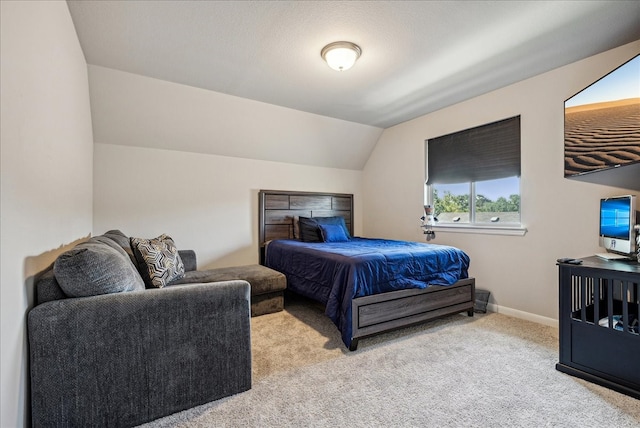 bedroom featuring lofted ceiling and light carpet