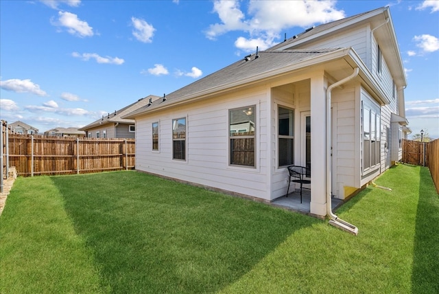 back of house featuring a lawn and a patio area