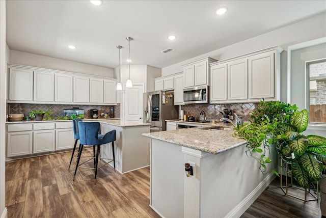 kitchen featuring appliances with stainless steel finishes, hardwood / wood-style floors, and decorative backsplash