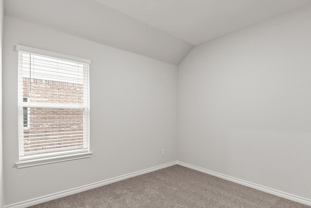 unfurnished room featuring lofted ceiling and carpet floors