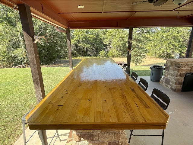 deck featuring ceiling fan, a patio area, and a lawn