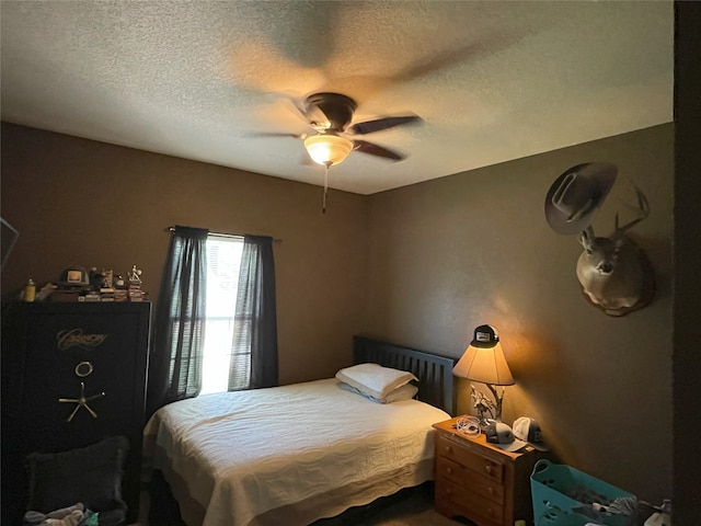 bedroom with ceiling fan and a textured ceiling