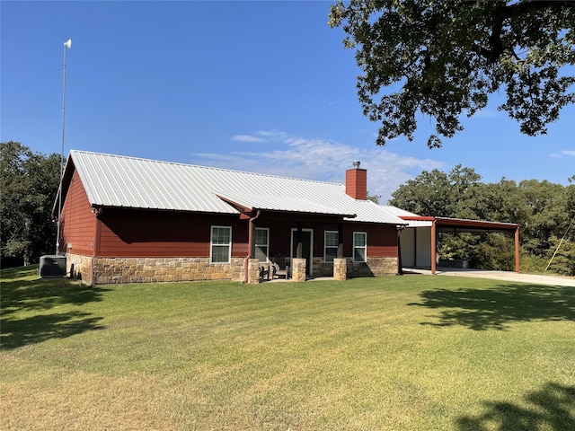 back of house featuring a yard, a carport, and central AC