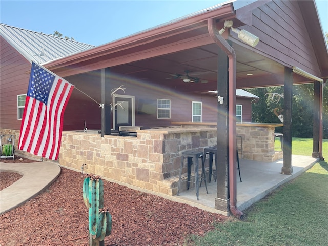 view of patio / terrace with ceiling fan and an outdoor bar