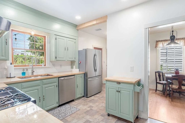 kitchen with sink, light hardwood / wood-style flooring, tasteful backsplash, stainless steel appliances, and pendant lighting