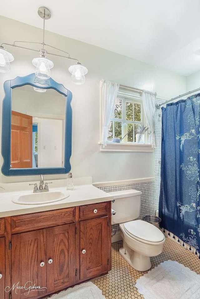 bathroom with tile patterned flooring, a shower with shower curtain, vanity, and toilet