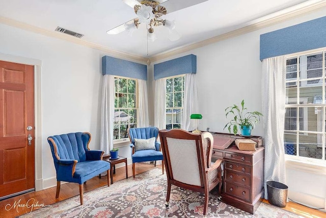 office area featuring light wood-type flooring, ornamental molding, and ceiling fan