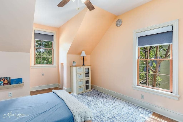 bedroom featuring ceiling fan, light wood-type flooring, and lofted ceiling