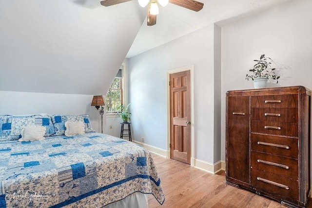 bedroom with ceiling fan, vaulted ceiling, and wood-type flooring