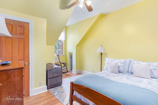 bedroom featuring ceiling fan, light hardwood / wood-style flooring, and lofted ceiling