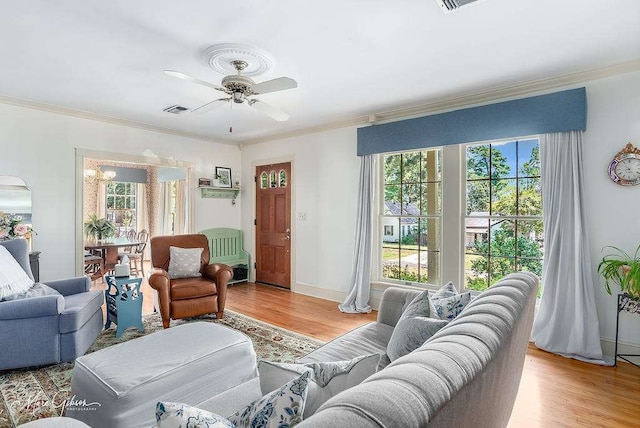 living room with ceiling fan, crown molding, and light hardwood / wood-style flooring