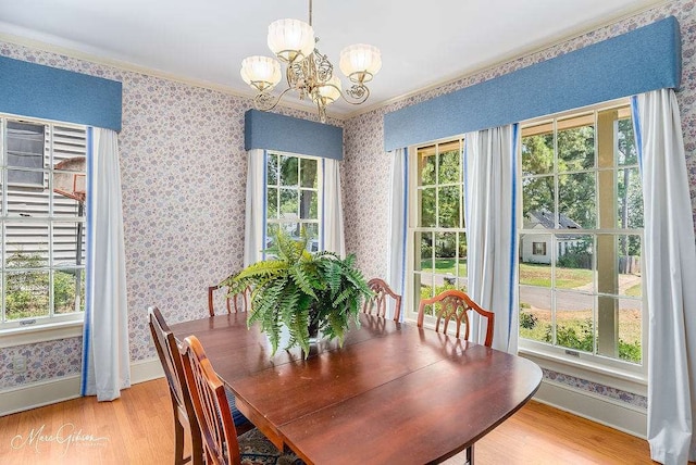 dining area with a wealth of natural light, light wood-type flooring, and an inviting chandelier