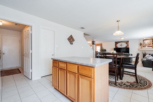 kitchen with a kitchen island, decorative light fixtures, and light tile patterned flooring