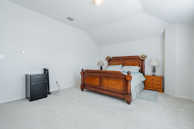 bedroom with light carpet and lofted ceiling