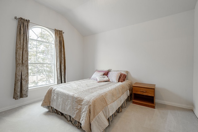 bedroom with vaulted ceiling, multiple windows, and light carpet