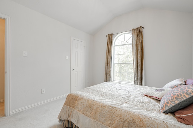 carpeted bedroom with lofted ceiling