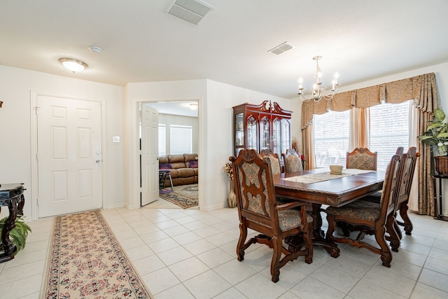 tiled dining room with a notable chandelier and plenty of natural light