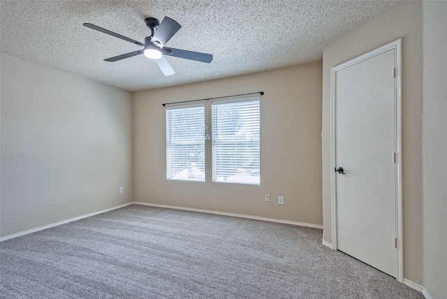 unfurnished bedroom featuring carpet floors, ceiling fan, a textured ceiling, and baseboards