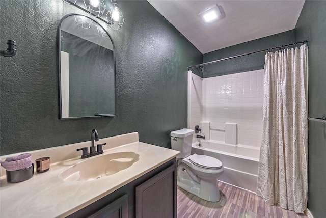 full bathroom featuring a textured wall, toilet, wood finished floors, shower / bath combo with shower curtain, and vanity