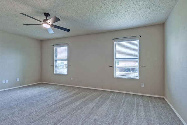 carpeted empty room featuring a ceiling fan, a textured ceiling, and baseboards