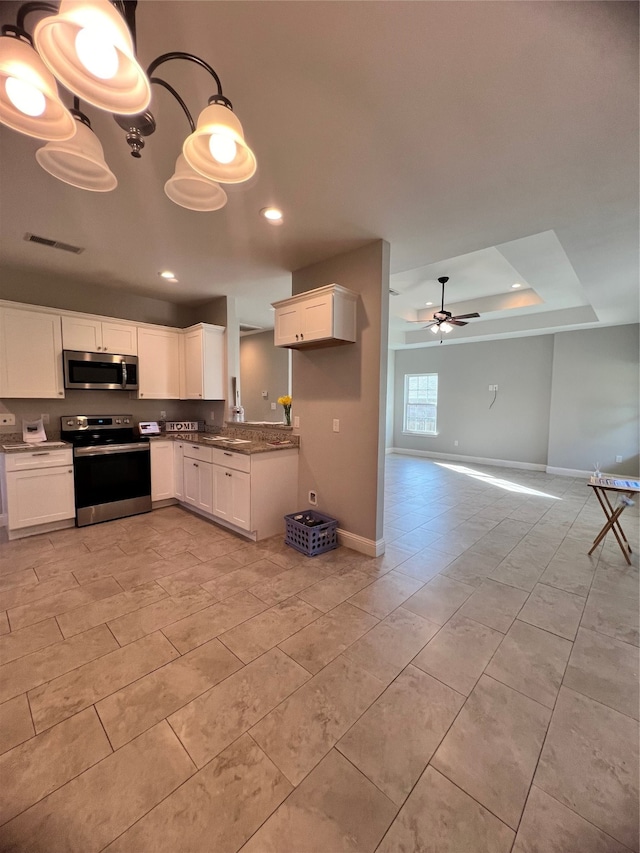 kitchen with appliances with stainless steel finishes, white cabinetry, an inviting chandelier, and hanging light fixtures