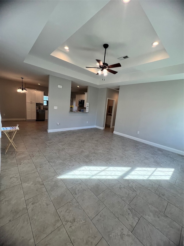 spare room with a raised ceiling, a wealth of natural light, and ceiling fan