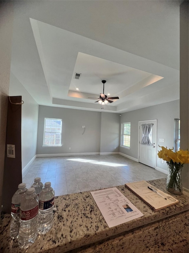 interior space featuring a tray ceiling and ceiling fan