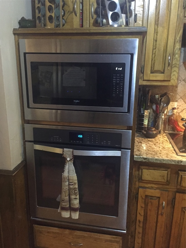 room details with light stone countertops and appliances with stainless steel finishes