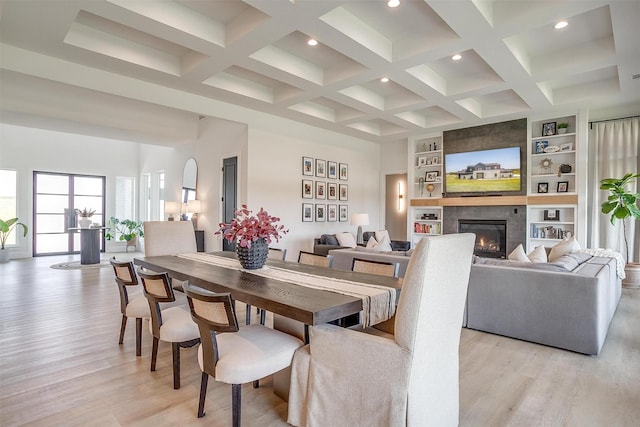 dining area with light wood-type flooring, beam ceiling, and coffered ceiling