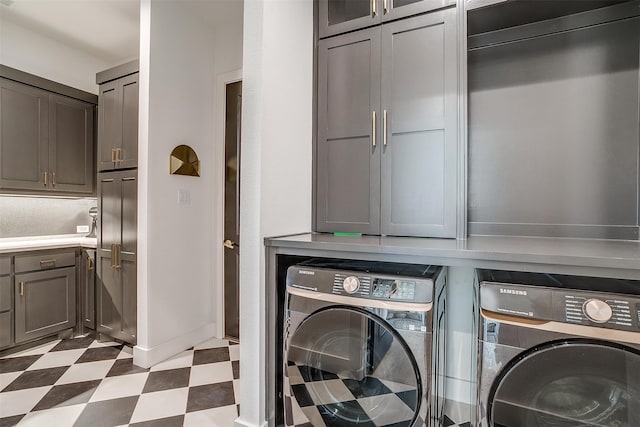 clothes washing area with washer and dryer and cabinets