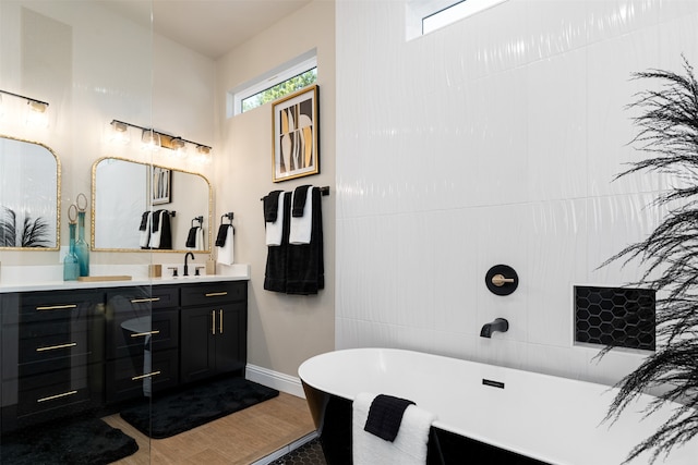 bathroom with a bathing tub, wood-type flooring, and vanity