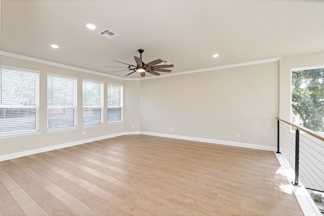 empty room featuring ornamental molding, light wood-type flooring, and a wealth of natural light