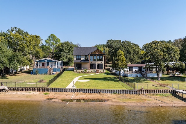 rear view of house with a yard and a water view