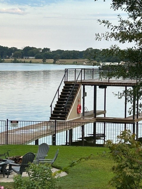 dock area featuring a lawn and a water view