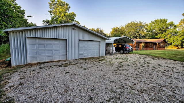 garage with a carport and a lawn