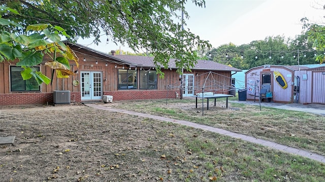 view of yard with central AC unit and french doors