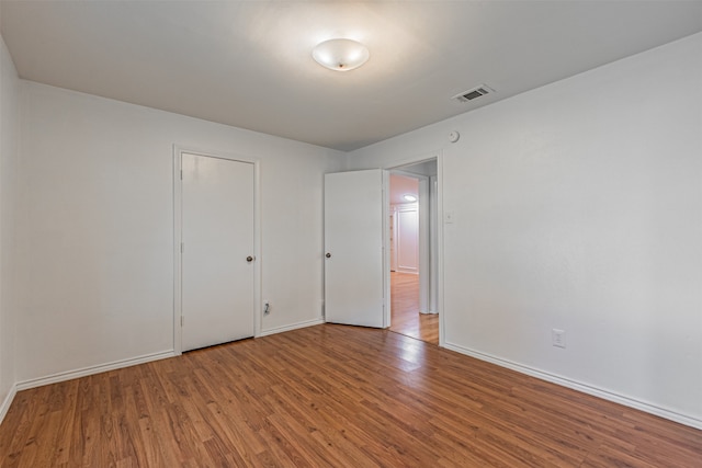 unfurnished bedroom with a closet and hardwood / wood-style floors