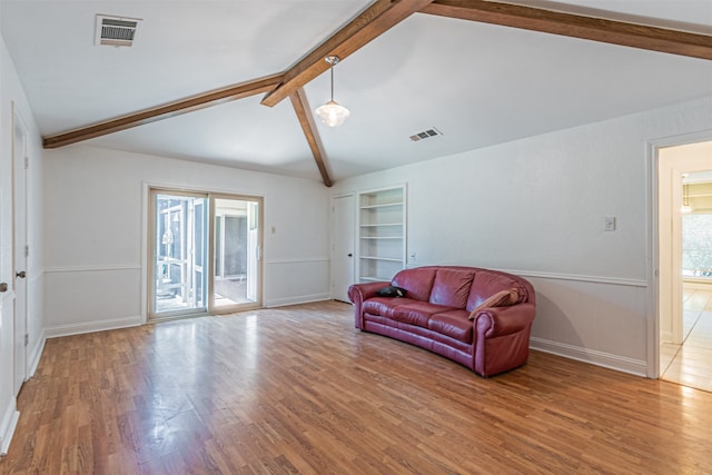 interior space featuring lofted ceiling with beams and light hardwood / wood-style floors