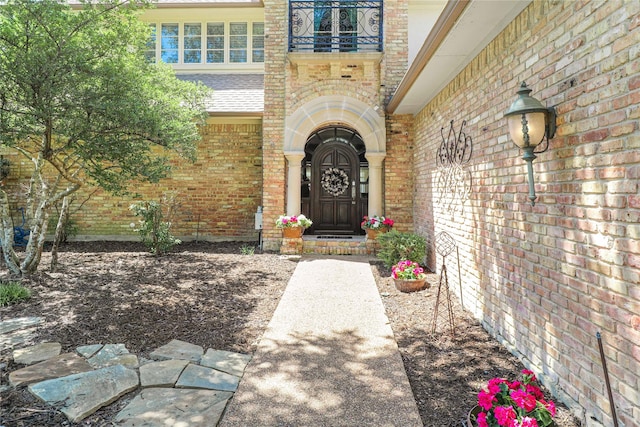 view of exterior entry featuring a balcony