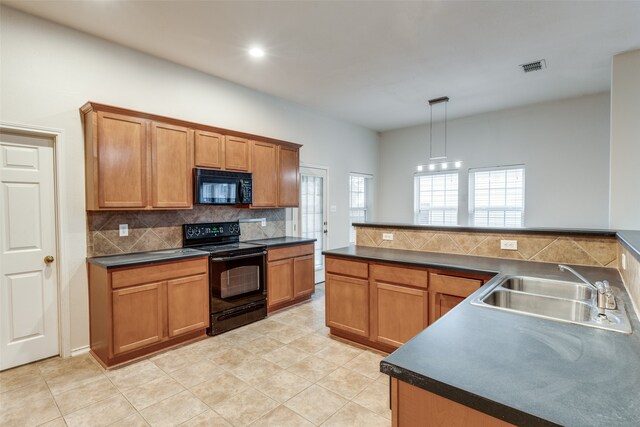 kitchen with tasteful backsplash, light tile patterned floors, black appliances, sink, and hanging light fixtures