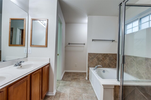 bathroom with a tub to relax in, vanity, and tile patterned floors