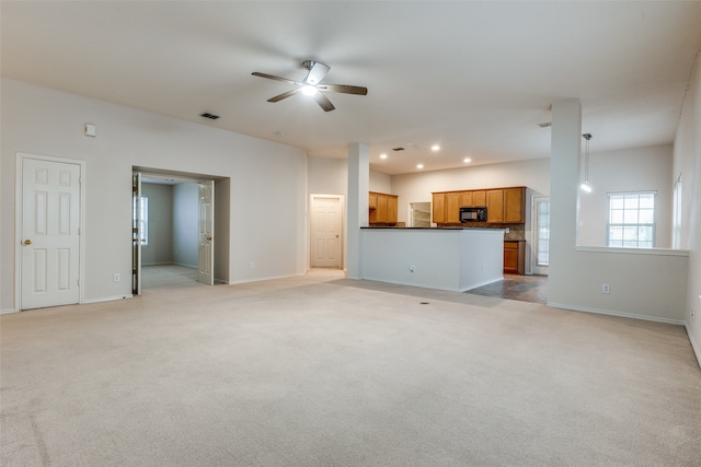 unfurnished living room featuring light colored carpet and ceiling fan