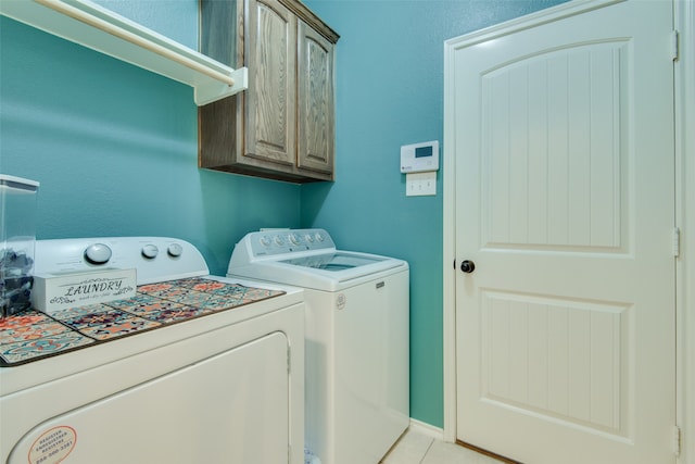 laundry area featuring separate washer and dryer, cabinets, and light tile patterned flooring